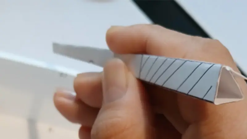 Paper chopstick sleeve in hand, showcasing a custom triangular design with printed details.