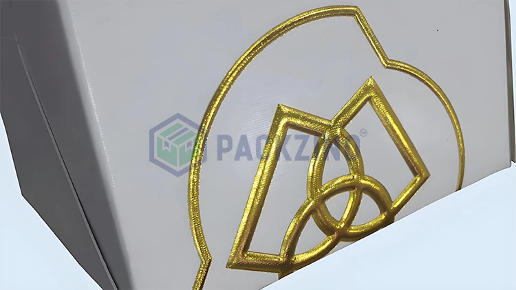 White packaging box with embossed gold foil stamping and intricate logo design