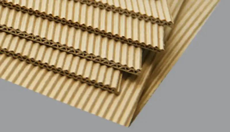 A stack of 4-layer B flute corrugated boards showing wavy fluting lines