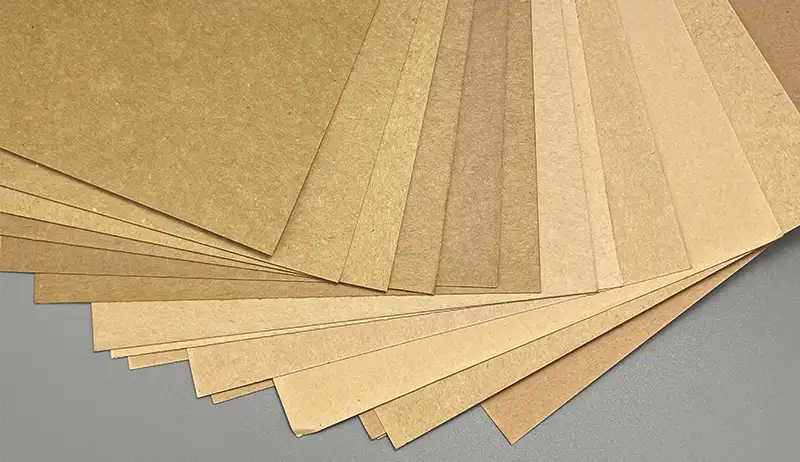 A fan of uncoated natural brown kraft paper sheets in different tones