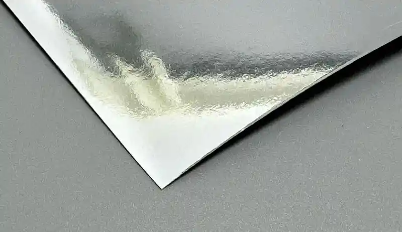 Silver metallic paper sheet with a glossy mirror-like reflective finish