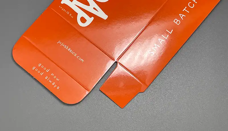 Glossy lamination with reflective surface on green printed box.