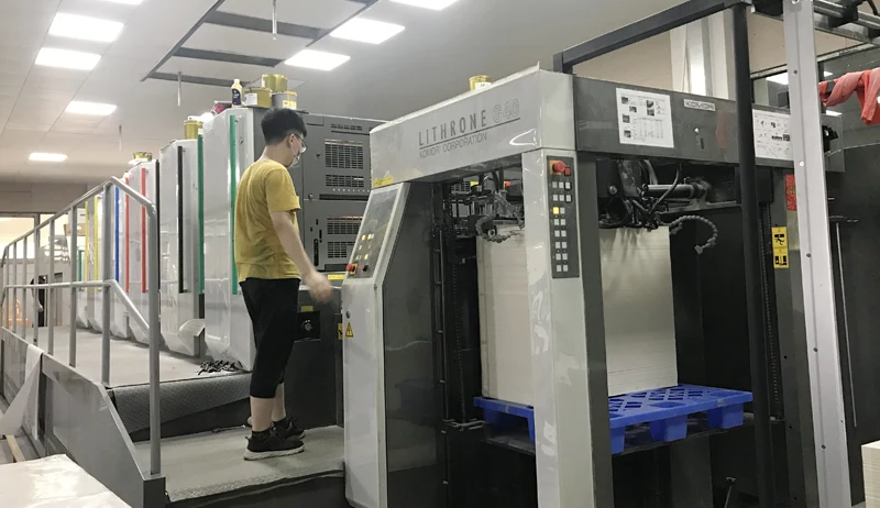 Operator running a Komori Lithrone 5-color offset printing press