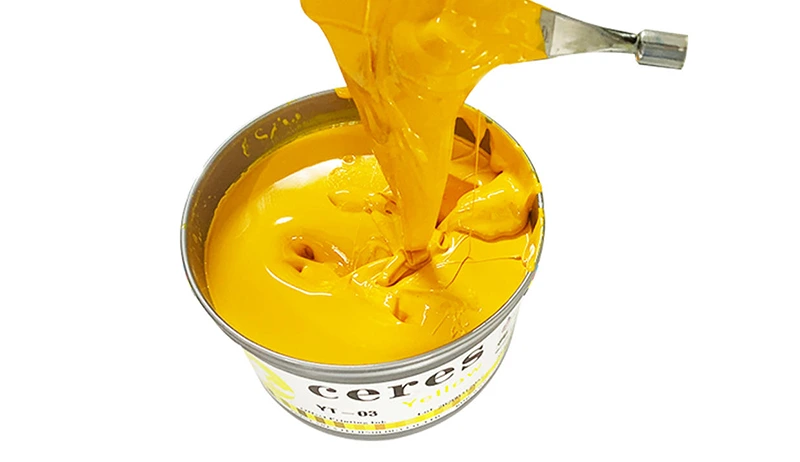 Viscous yellow UV-curable ink being lifted with spatula