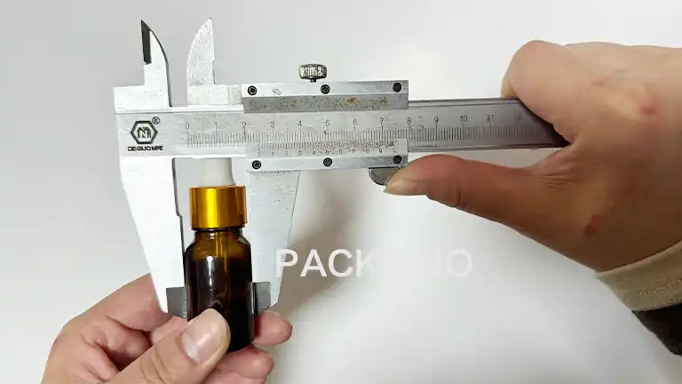 Measuring bottle width with caliper for packaging customization