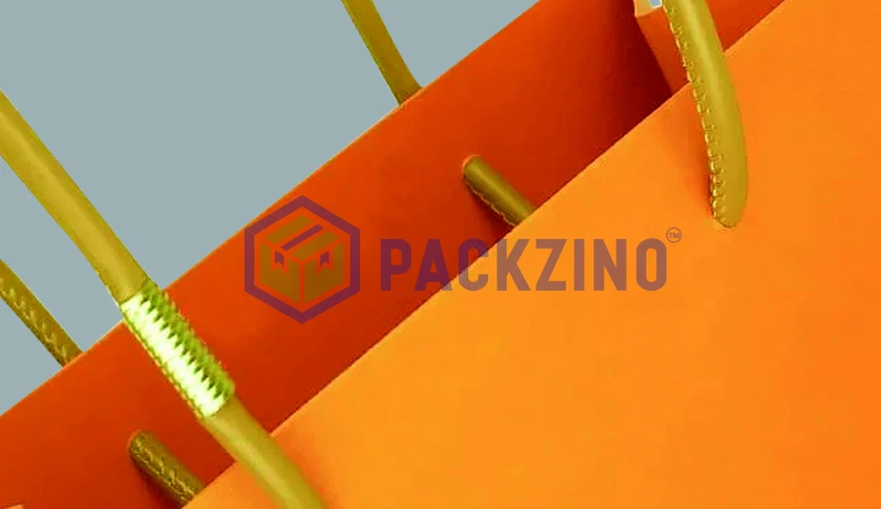 Orange paper bag with stitched yellow rope loop handles