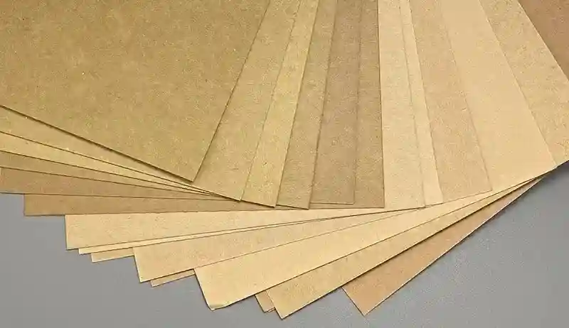 A fan of uncoated natural brown kraft paper sheets in different tones