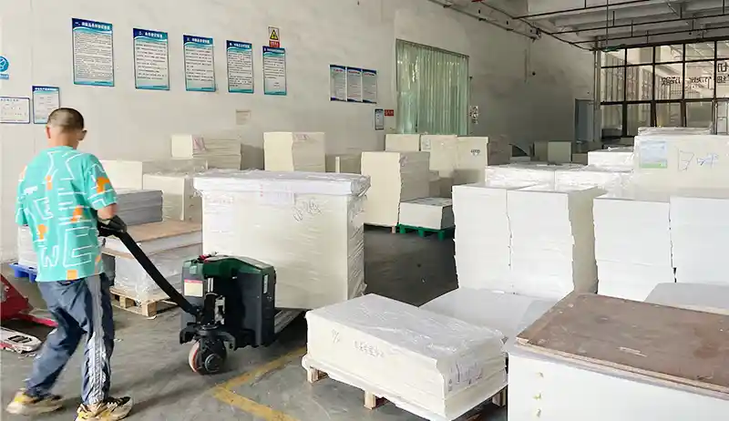 A worker at a China packaging manufacturer moves paper materials inside the factory.
