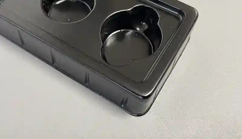 Close-up of a black plastic insert tray for chocolate gift boxes, designed for shaped truffles.