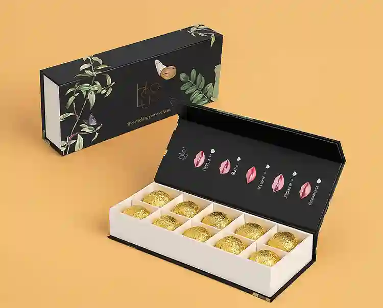 Chocolate gift box with insert tray holding golden wrapped truffles in a rigid drawer box.