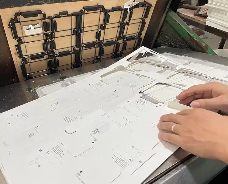Manual stripping process for custom packaging with die cut board and printed sheets