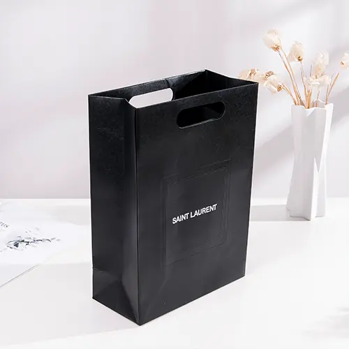Custom paper bag for cosmetics with die-cut handles, ideal for luxury packaging.