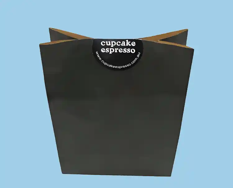 Minimalist paper bakery bag with round logo sticker, great for cupcakes and takeaway desserts.