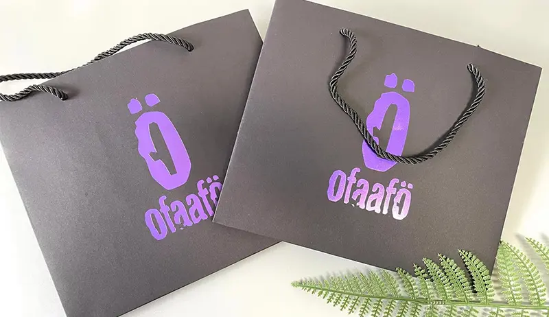 Custom purple paper bag with foil-stamped logo and rope handle for retail packaging