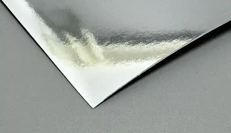 Silver metallic paper sheet with a glossy mirror-like reflective finish