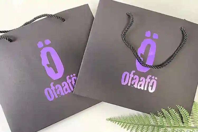 Rigid box with purple foil stamping logo on black surface