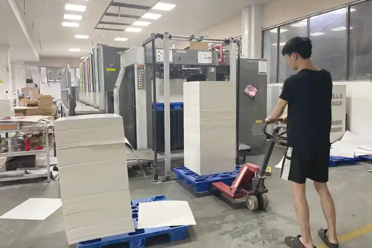 Worker handling packaging materials at eco-friendly box printing factory